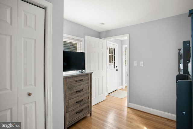 bedroom with light hardwood / wood-style floors and a closet