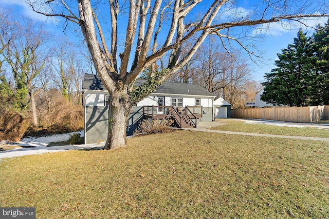 view of front of home with a garage, a deck, and a front lawn