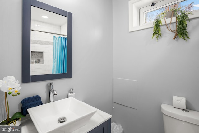 bathroom with vanity, curtained shower, and toilet