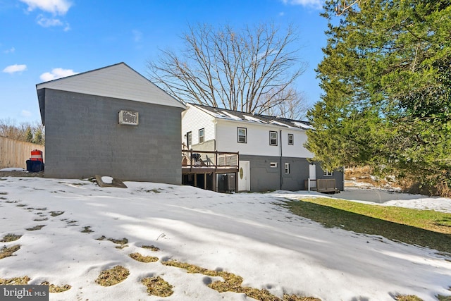 snow covered house featuring a deck