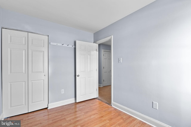 unfurnished bedroom with a closet and light hardwood / wood-style flooring