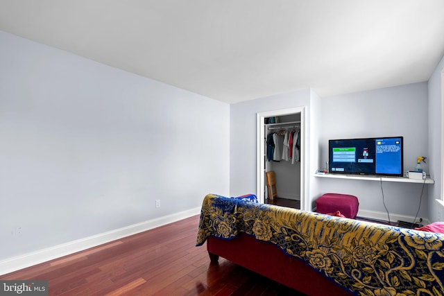 bedroom with a closet, a walk in closet, and dark hardwood / wood-style floors