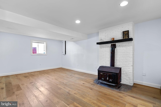 unfurnished living room with light hardwood / wood-style floors and a wood stove