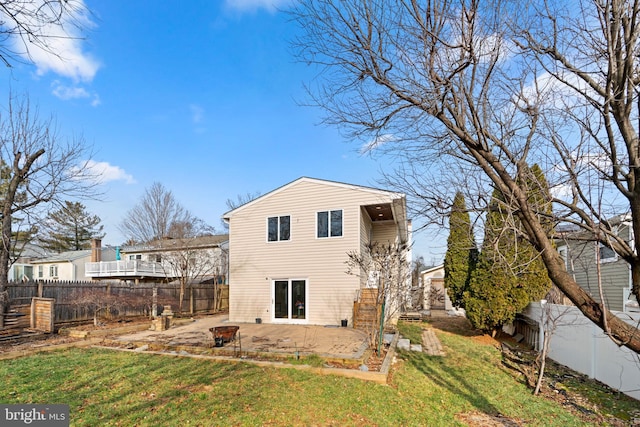 back of house featuring a yard, a patio, and an outdoor fire pit