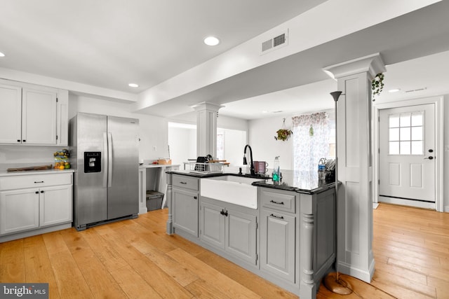 kitchen with sink, ornate columns, stainless steel fridge, gray cabinets, and light hardwood / wood-style floors