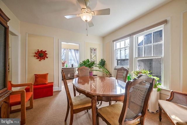 dining space featuring plenty of natural light, a ceiling fan, and light colored carpet