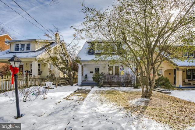 view of front of property featuring fence and a porch