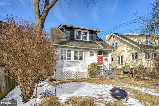 view of front of house with a shingled roof and fence