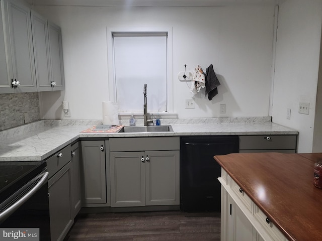 kitchen featuring sink, gray cabinets, dark hardwood / wood-style floors, tasteful backsplash, and black appliances