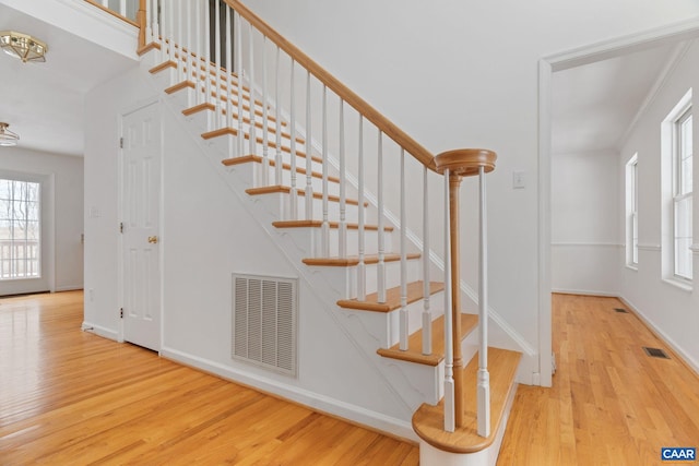 stairway featuring hardwood / wood-style flooring and ornamental molding