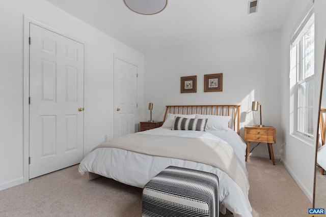 bedroom featuring multiple windows and light colored carpet