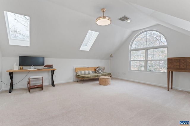 carpeted office space featuring vaulted ceiling with skylight