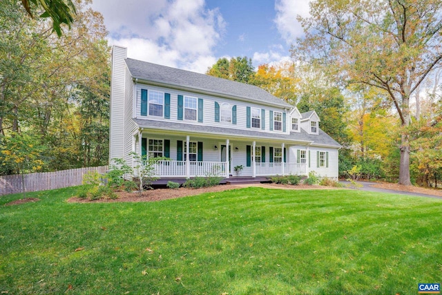 colonial house featuring a porch and a front yard