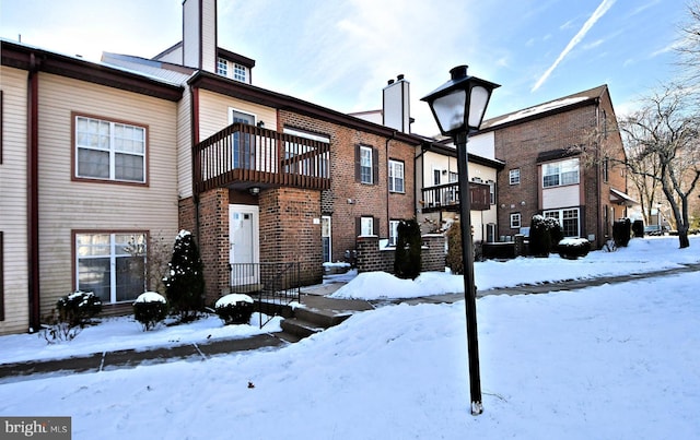 view of snow covered rear of property