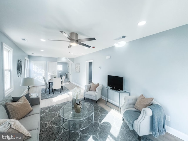 living room with wood-type flooring and ceiling fan