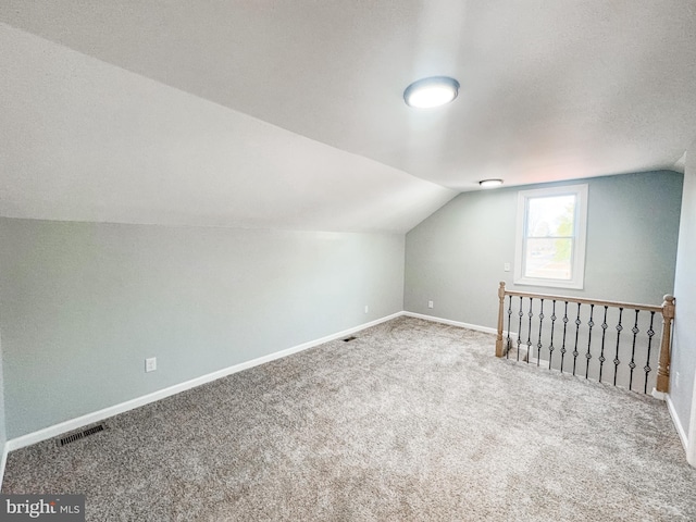 additional living space with lofted ceiling and carpet flooring