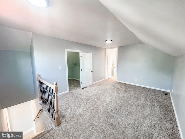 bonus room with carpet flooring and vaulted ceiling