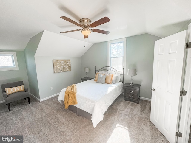 bedroom with vaulted ceiling, carpet, and multiple windows