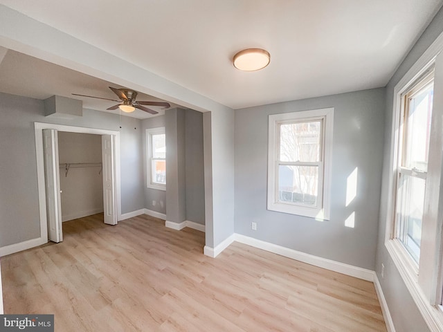 unfurnished bedroom with multiple windows, a closet, and light hardwood / wood-style flooring