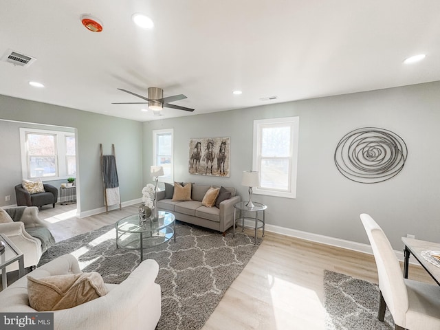 living room featuring plenty of natural light, ceiling fan, and light hardwood / wood-style flooring