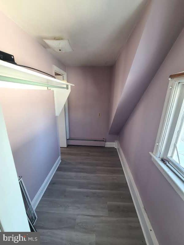 stairway featuring hardwood / wood-style flooring and a baseboard heating unit