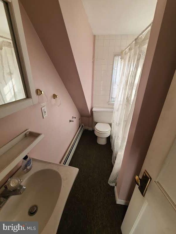 bathroom with sink, toilet, and baseboard heating