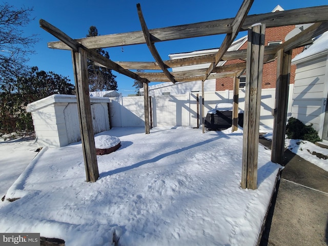 snow covered patio featuring a storage unit