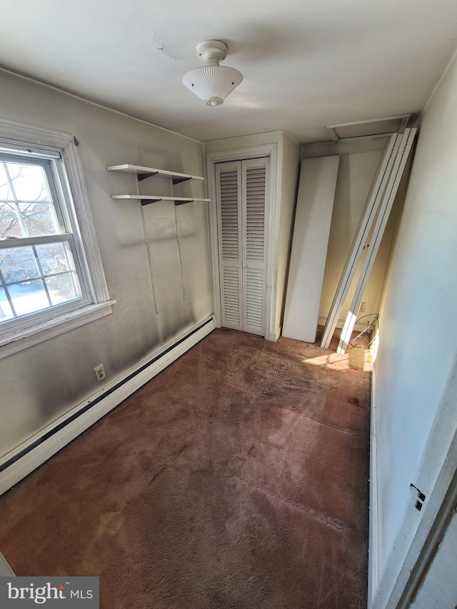 unfurnished bedroom with a baseboard heating unit and carpet flooring