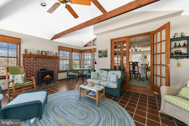 tiled living room featuring lofted ceiling with beams and ceiling fan with notable chandelier