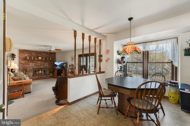 dining room with baseboards, a healthy amount of sunlight, ceiling fan, and a fireplace