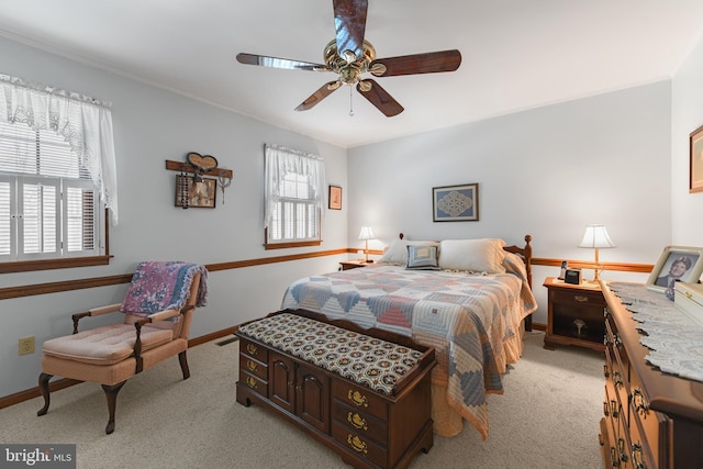 bedroom featuring visible vents, light carpet, a ceiling fan, crown molding, and baseboards