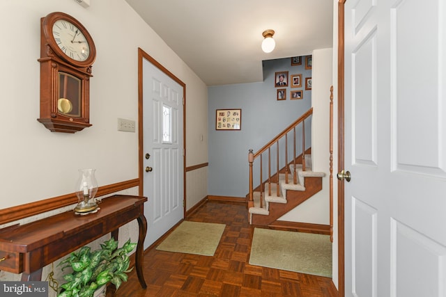 foyer entrance featuring stairway and baseboards