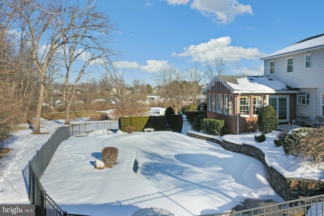 yard layered in snow featuring a fenced backyard