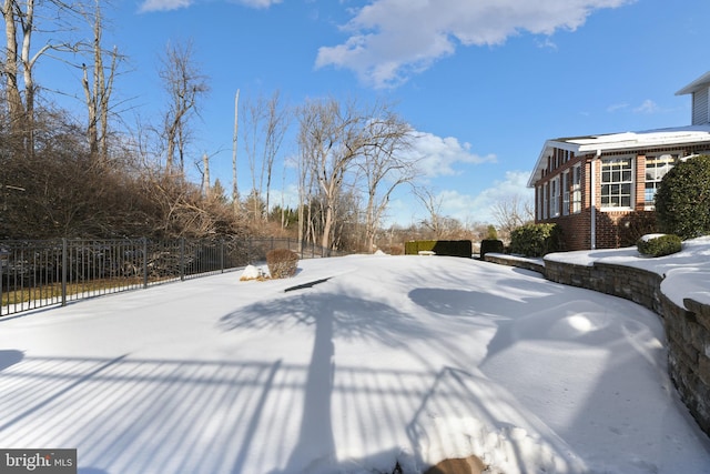 snowy yard with fence