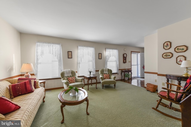 carpeted living area featuring a wainscoted wall