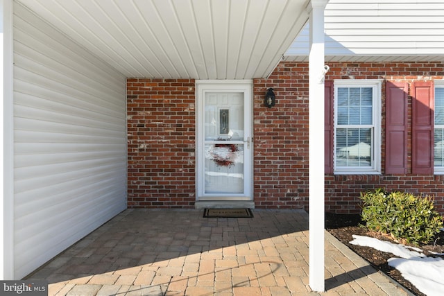 view of exterior entry featuring brick siding