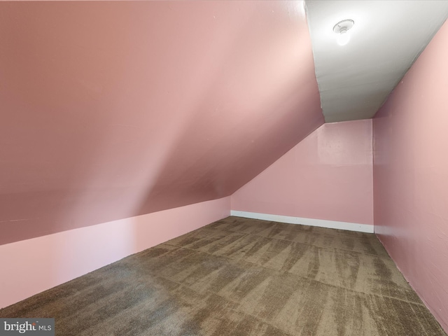 additional living space featuring lofted ceiling and carpet flooring