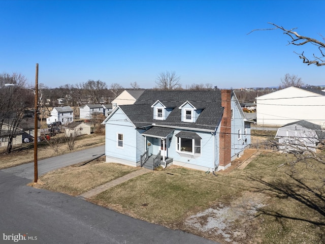 view of front of home with aphalt driveway, fence, roof with shingles, a chimney, and a front yard