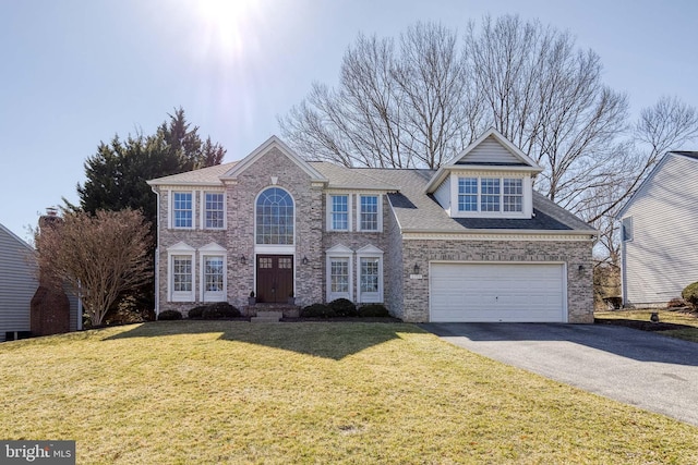 traditional-style home with an attached garage, a front yard, aphalt driveway, and brick siding