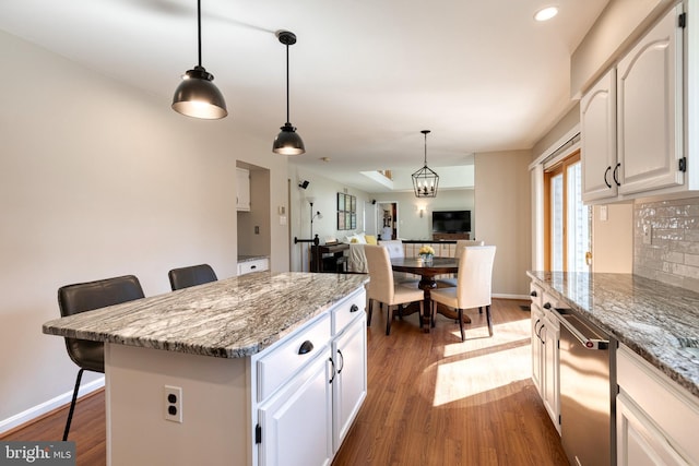 kitchen featuring hanging light fixtures, dark wood-style floors, a breakfast bar, and a center island