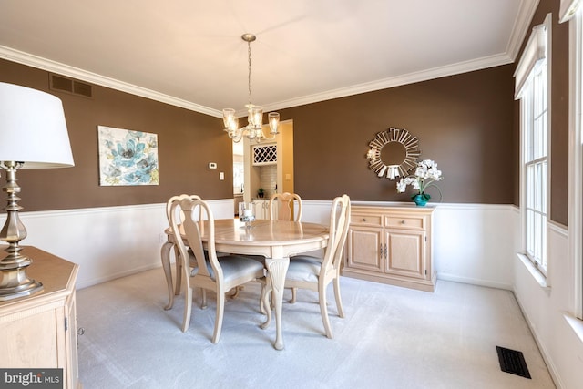 dining area with ornamental molding, visible vents, and light colored carpet