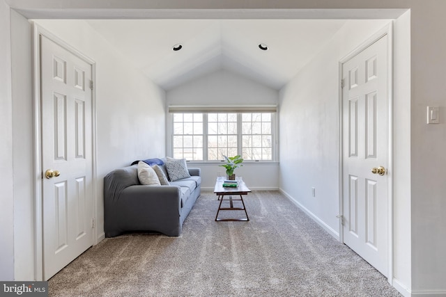 carpeted living area featuring vaulted ceiling and baseboards