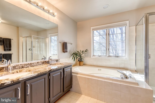 full bathroom featuring double vanity, a sink, a shower stall, tile patterned flooring, and a bath