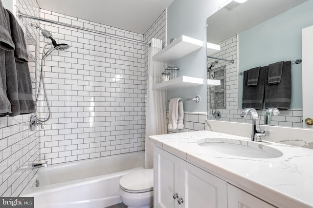 bathroom with tile walls, vanity, toilet, and shower / bathtub combination