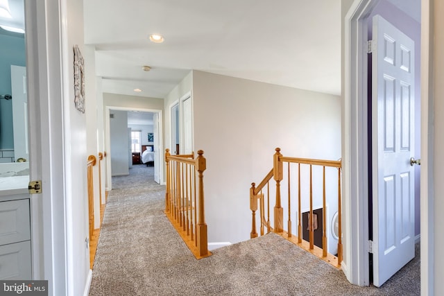 hall with light carpet and an upstairs landing