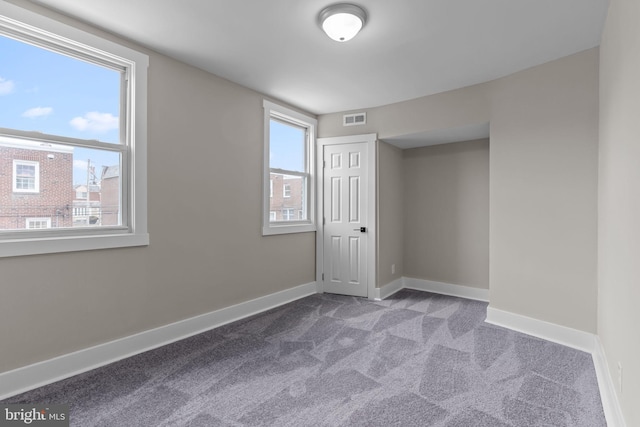 carpeted spare room featuring a wealth of natural light