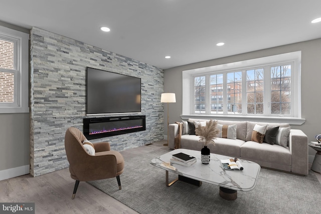 living room featuring a stone fireplace and light wood-type flooring