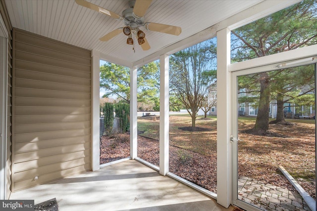 unfurnished sunroom with ceiling fan