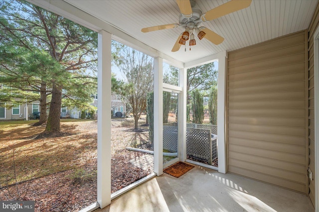 unfurnished sunroom with ceiling fan