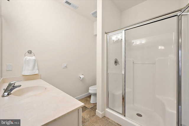 bathroom with vanity, toilet, and a shower with door